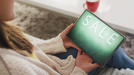 caucasian woman using tablet at home for online shopping, slow motion