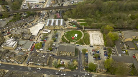 a drone shot hyperlapse of a busy and bustling todmorden town centre , showing lots of traffic , lots of people and lots of action