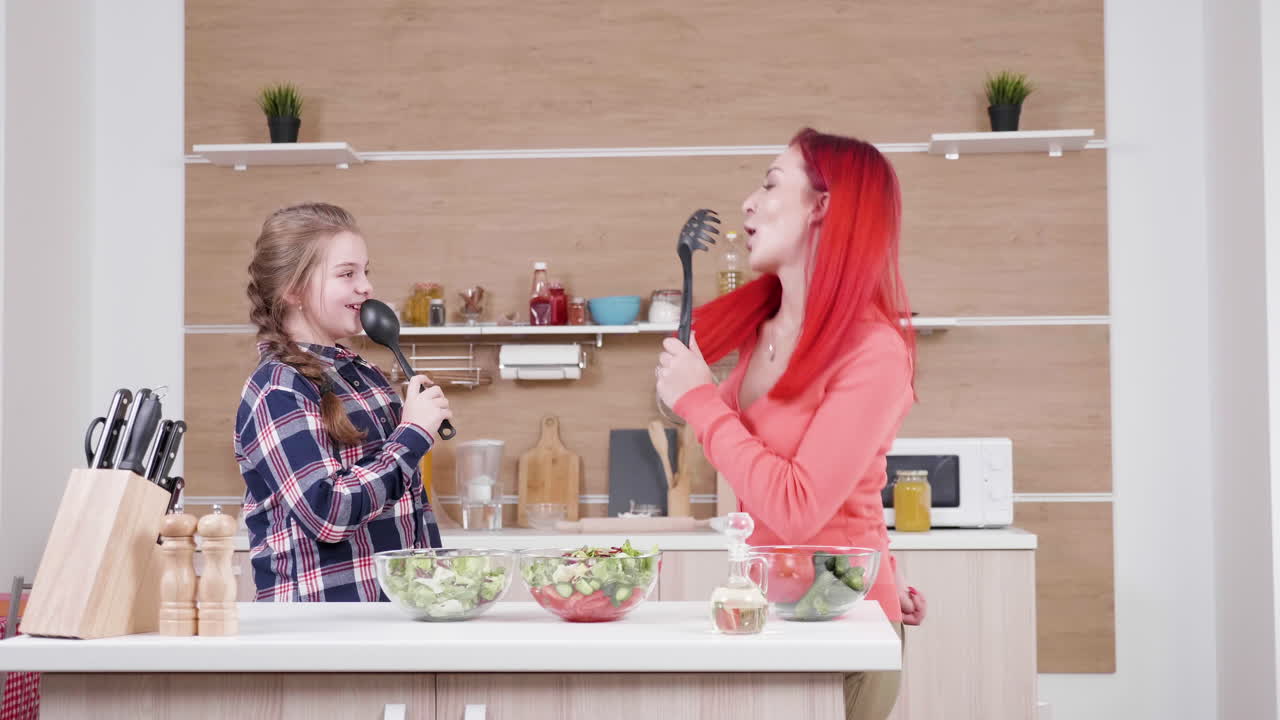 Mother and Daughter Singing in the Kitchen