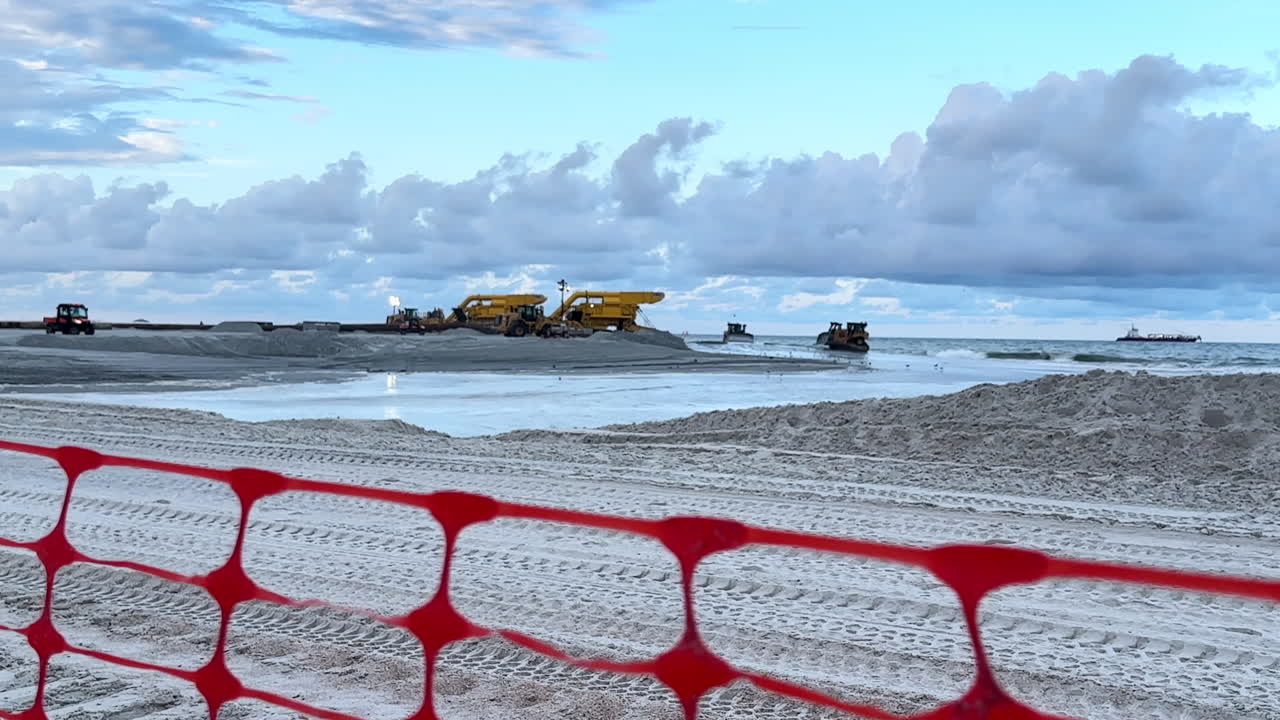 Beach Construction Project: Heavy Machinery Moving Sand on the Shoreline