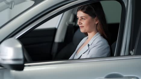 beautiful adult girl smiling while driving a new car