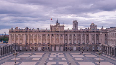 day to night timelapse ar royal palace in madrid, spain. 
aerial view from the balcony of the catedral. clouds moving during sunset and lights tourning on .