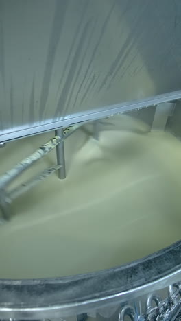 industrial equipment for making butter. modern container mixing butter at milk factory. creamy dairy product in a tank vertical video