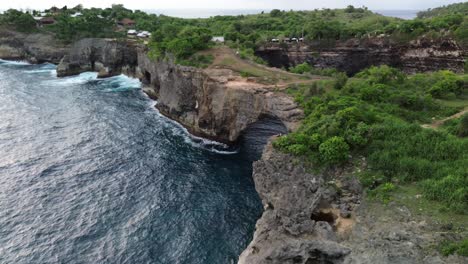 aerial view of broken beach cliffs, waves crashing against the rocks