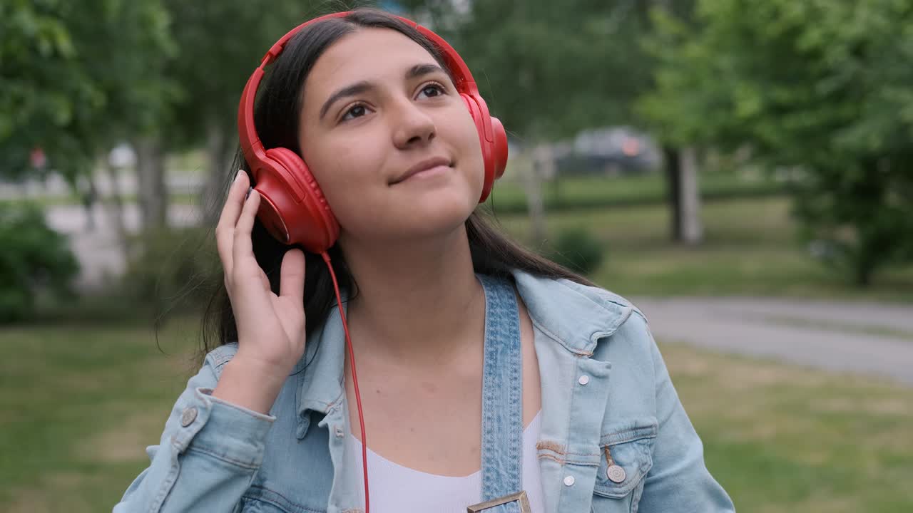 hermosa chica con auriculares rojos salta y escucha música