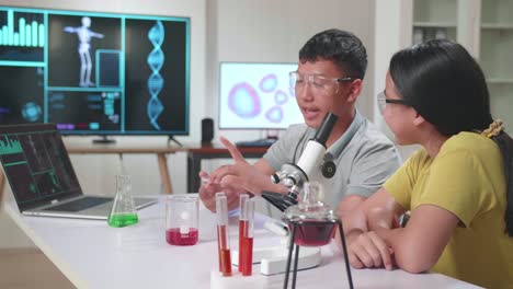 young asian boy and girl learning science experiment in laboratory at classroom. they are talking together