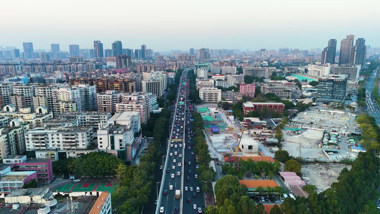 Wide drone shot of Guangzhou during sunset, showing busy rush hour traffic on the highways. China