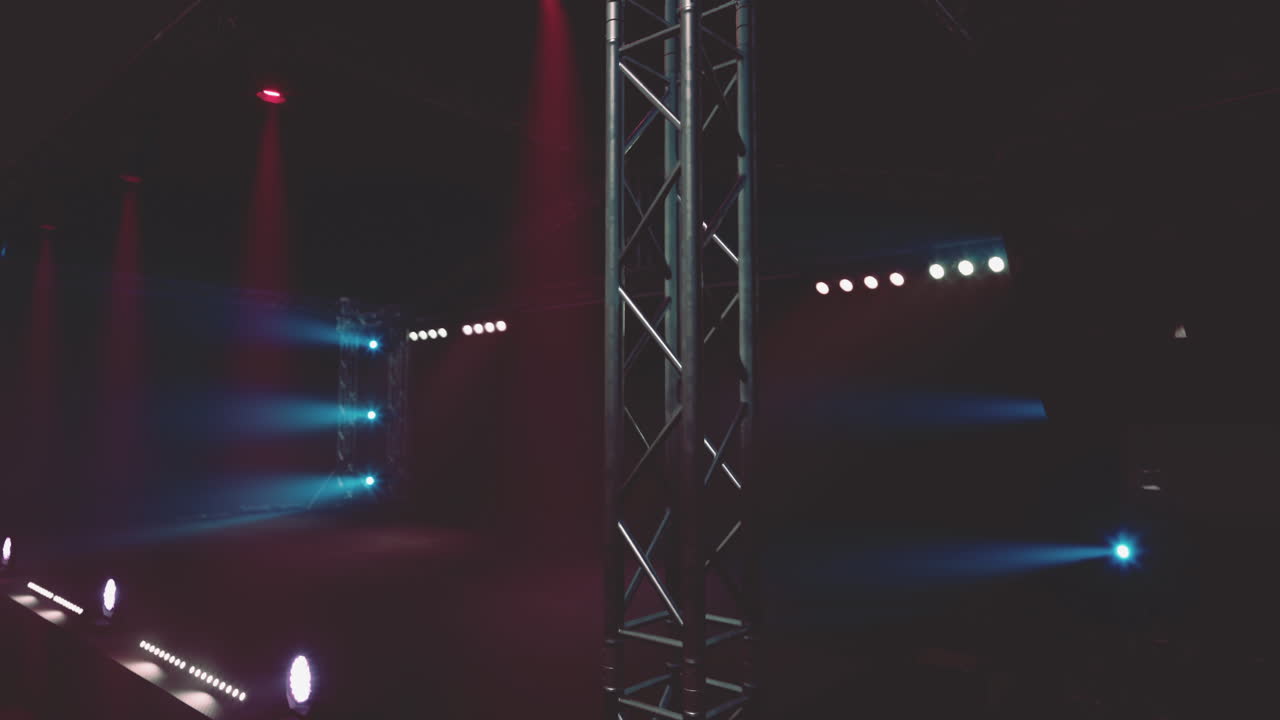 escenario de concierto oscuro con focos azules y rojos