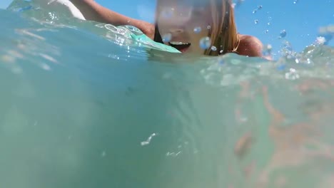 la mujer está surfeando en el mar.