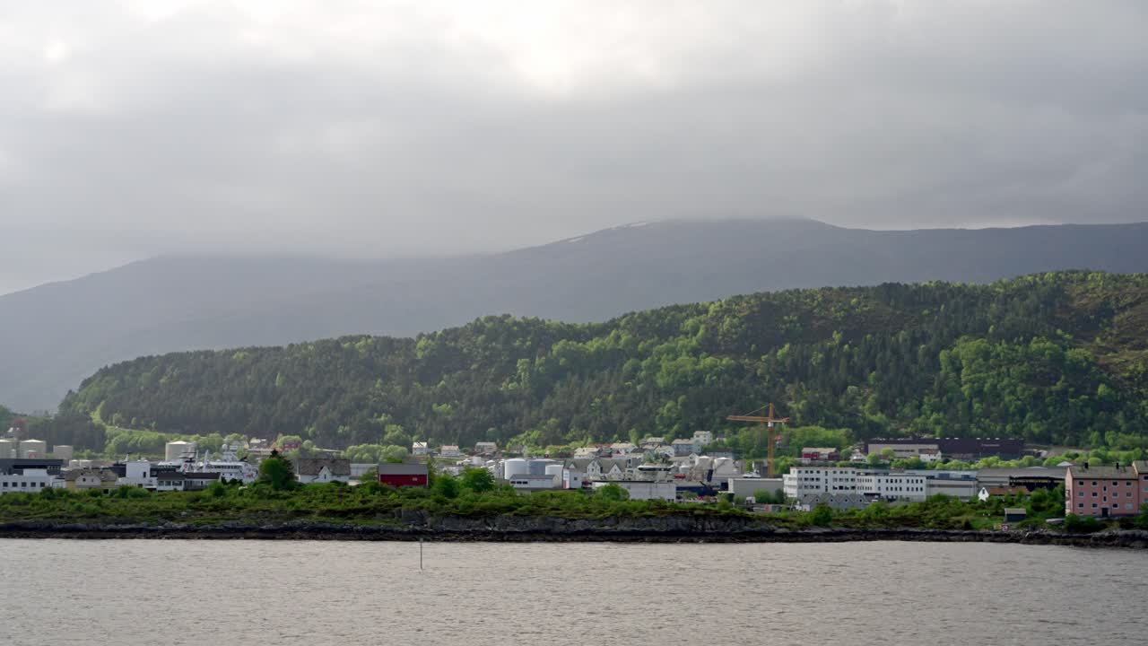 A voyage from the port of Bergen heading north, with the harbor and city buildings in the background