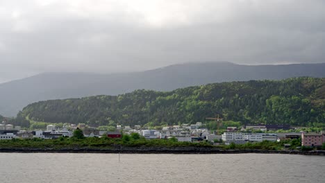 a voyage from the port of bergen heading north, with the harbor and city buildings in the background
