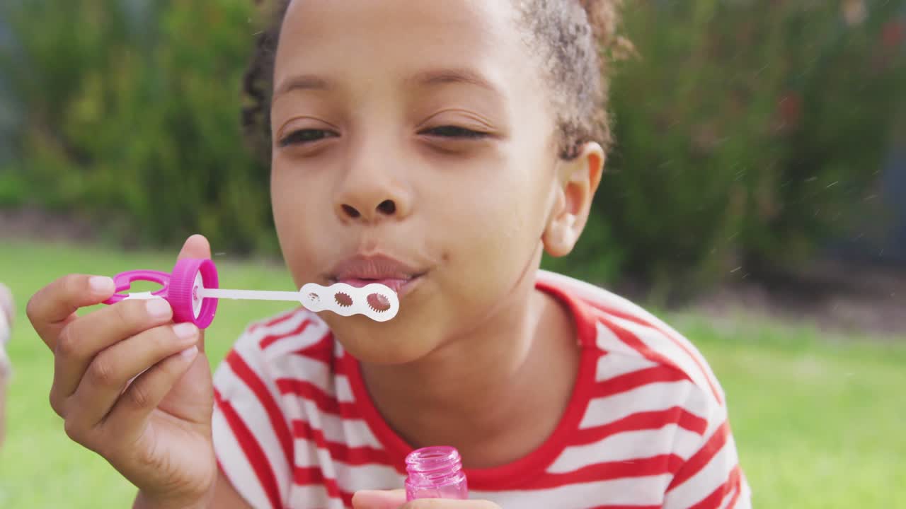 African american girl doing bubbles outside