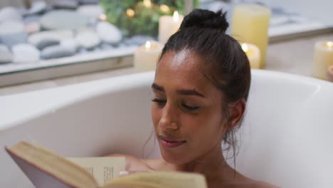 mujer de raza mixta acostada en una bañera en casa