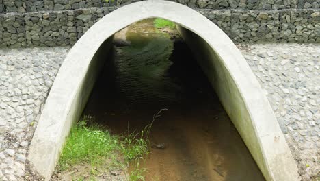 Vista-Al-Canal-Del-Río-En-El-Parque,-Pequeño-Puente-De-Piedra,-Inclinado-Hacia-Arriba