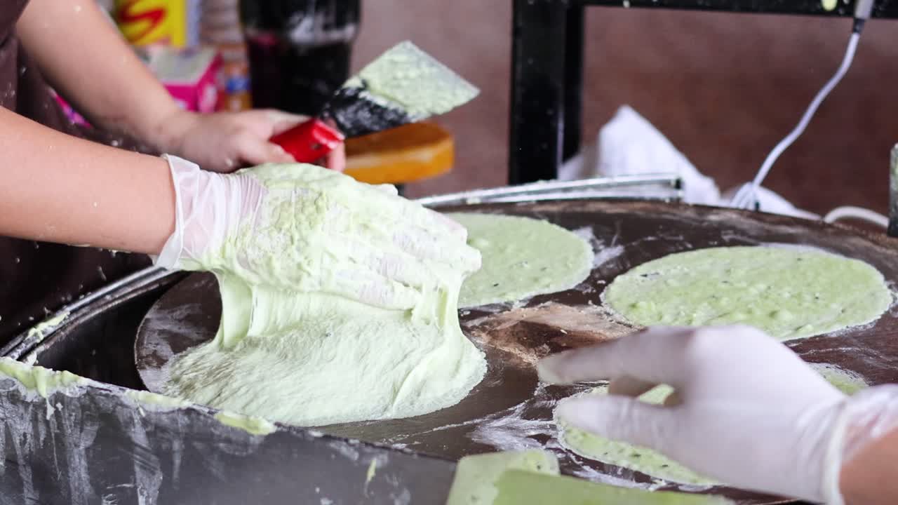 뜨거운 그릴에서 녹색 크레프를 준비하고 조리하는 것