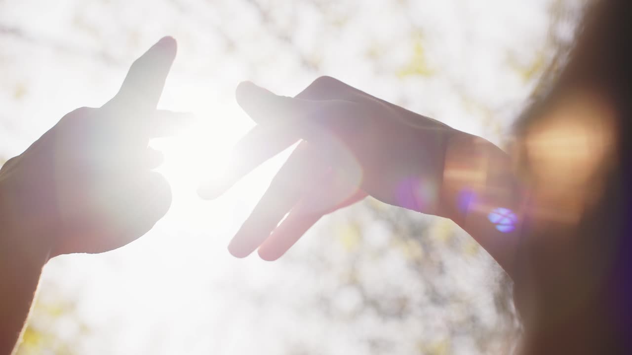 A Serene Moment of Connection: Hands Together in Light, Emphasizing the Beauty of Touch and Unity in a Tranquil Outdoor Setting