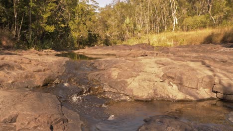 Arroyo-Que-Fluye-Hacia-Abajo-En-Un-Arroyo-Rocoso-Durante-La-Estación-Seca-Cerca-De-Cedar-Creek-Falls-En-Proserpine,-Australia