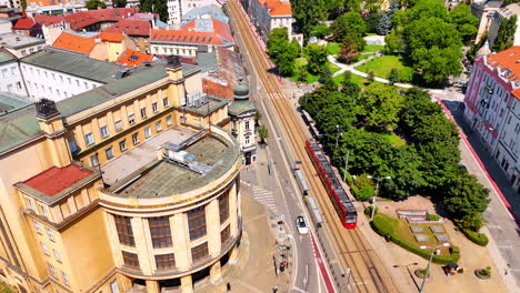 following the tram moving by the road in the city center of bratislava, slovakia. drone footage over the sunny cityscape.