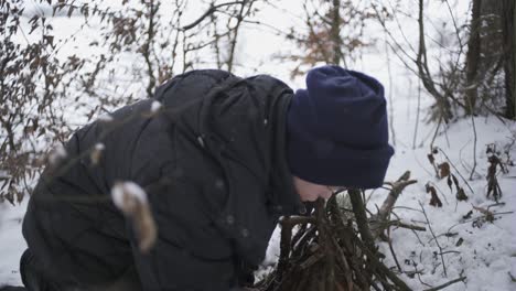 poor boy kindles a fire in the winter forest