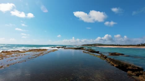 Waves-crashing-against-rocks-on-the-tropical-gorgeous-Brazilian-beach-of-Sibauma-near-Pipa-in-Rio-Grande-do-Norte,-Brazil-on-a-warm-sunny-summer-day