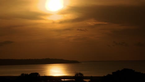 Sonnenuntergang-über-Dem-Rio-Negro-Oder-Dem-Schwarzen-Fluss-Mit-Der-Goldenen-Sonne,-Die-Auf-Der-Wasseroberfläche-Reflektiert-Wird---Zeitraffer