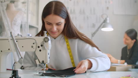 costura de ropa. costureras en el trabajo en el taller cosiendo ropa en la máquina de coser. modistas cosen ropa en el atelier. dos mujeres costureras. costura en el negocio de cosida.