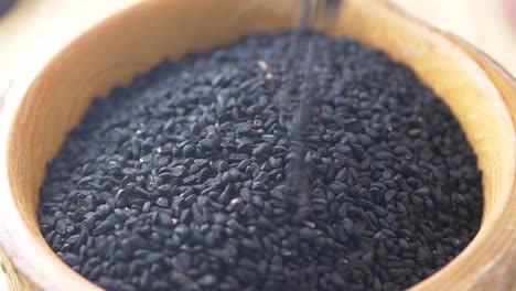 black cumin seeds in wooden bowl