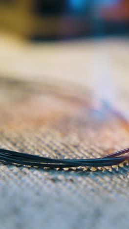 cu: heating of metal wire ring with gas burner flame on fireproof asbestos material in craft jewelry workshop closeup