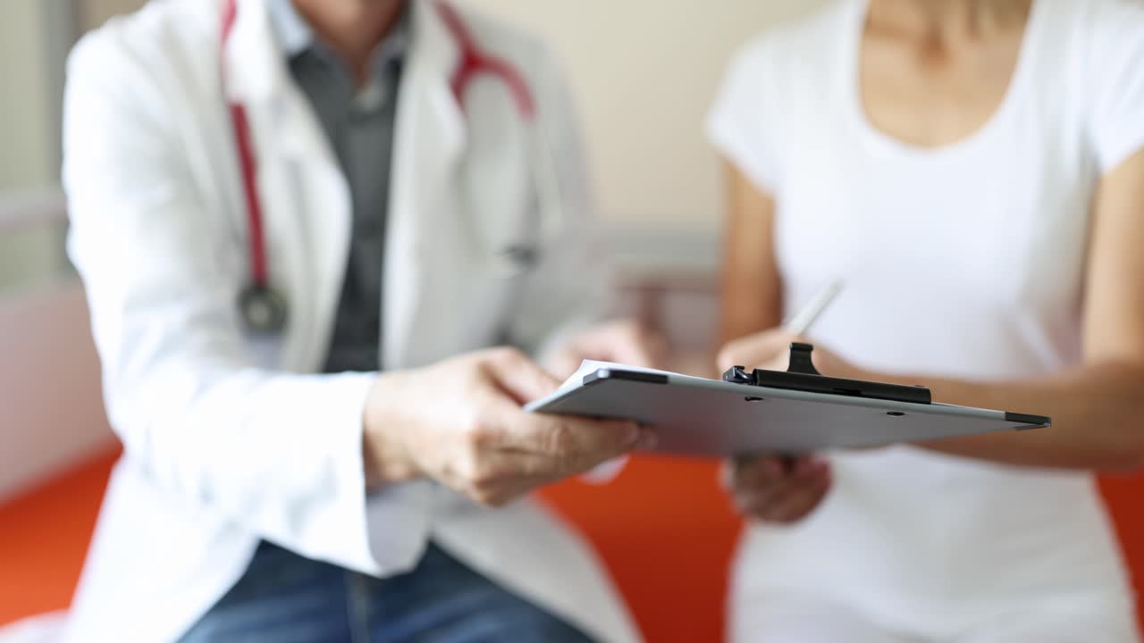 Médico entrega documentos médicos ao paciente para assinatura, vídeo 4k