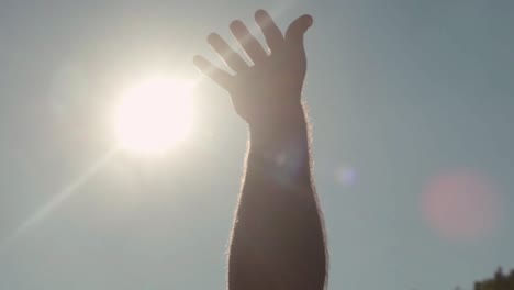 hand reaching towards the sun