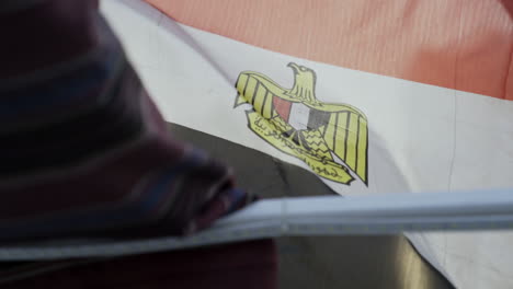 close up on egyptian flag blowing in wind with bar in foreground