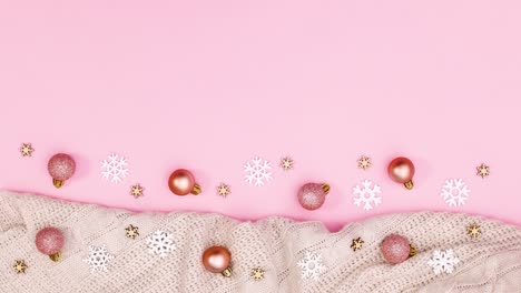 la decoración de navidad con adornos, copos de nieve y suéter aparecen en la parte inferior del tema rosa pastel.