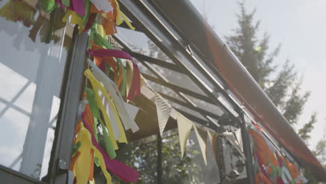 colorful streamers and bunting decorating an outdoor glass structure