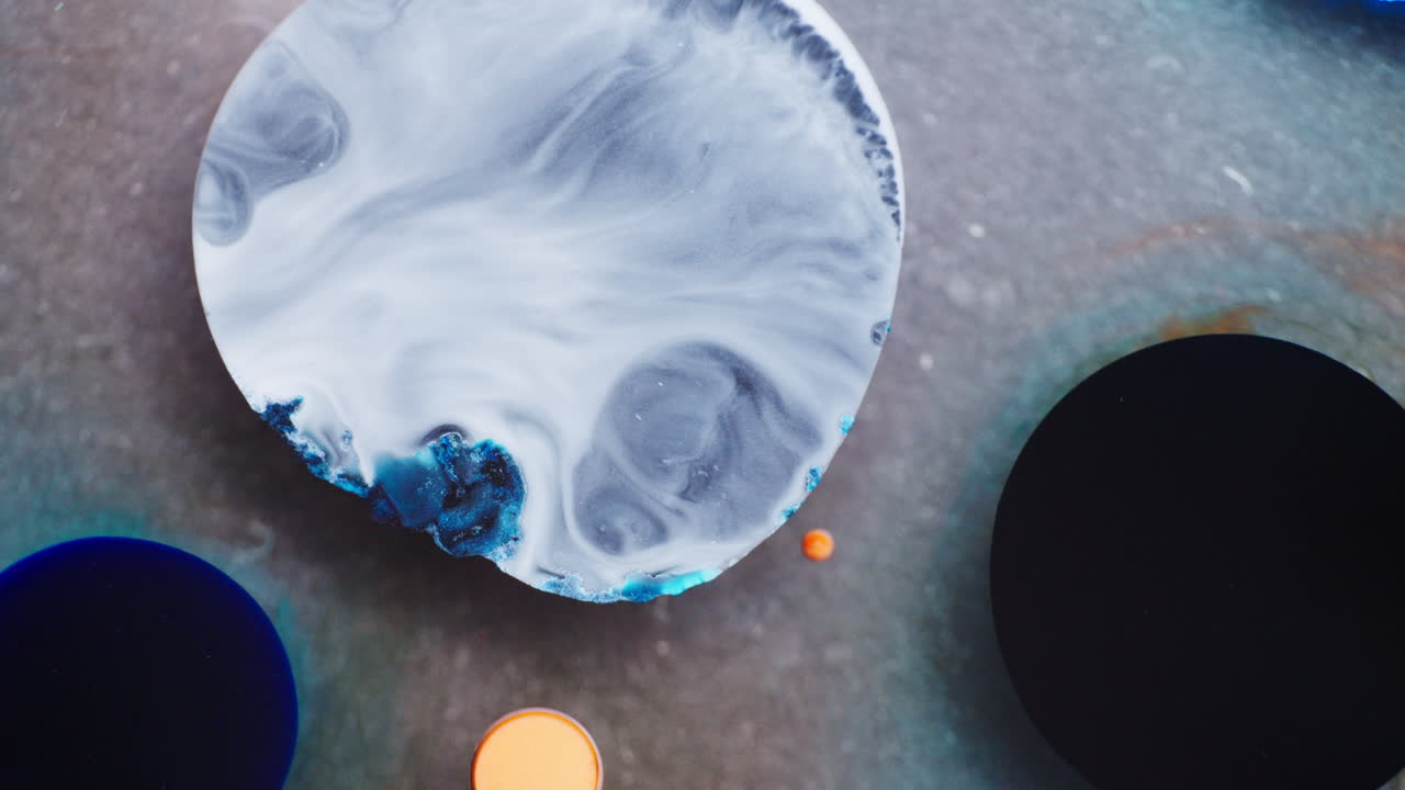 Explosion of white ink in black liquid upon pouring. Shimmering galaxy. Closeup