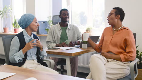 Muslim-Businesswoman,-Businesswoman-And-Young-Worker-Are-Talking-In-The-Office-While-Drinking-Coffee-2