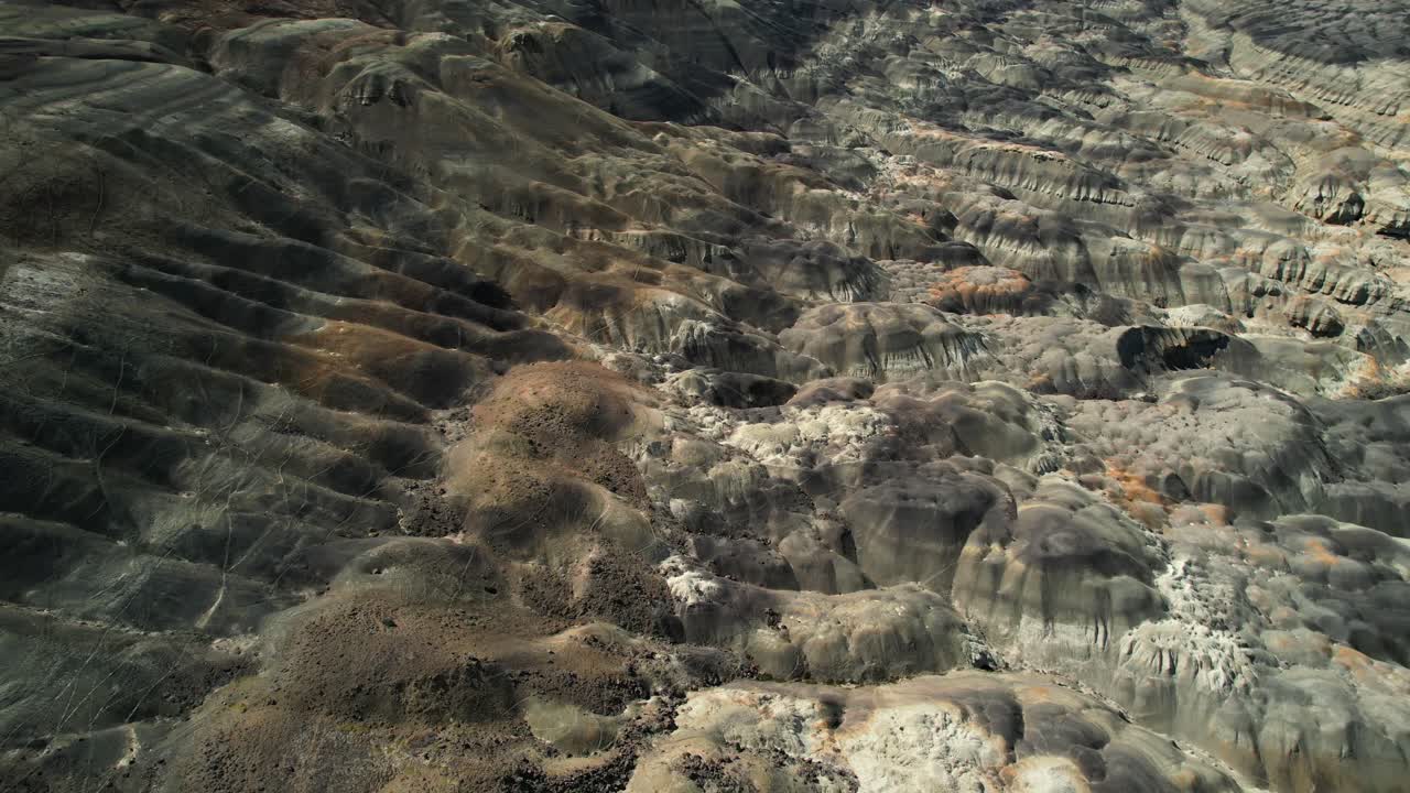 Paso aéreo de dron sobre el terreno erosionado y esculpido de las Badlands de la Patagonia.