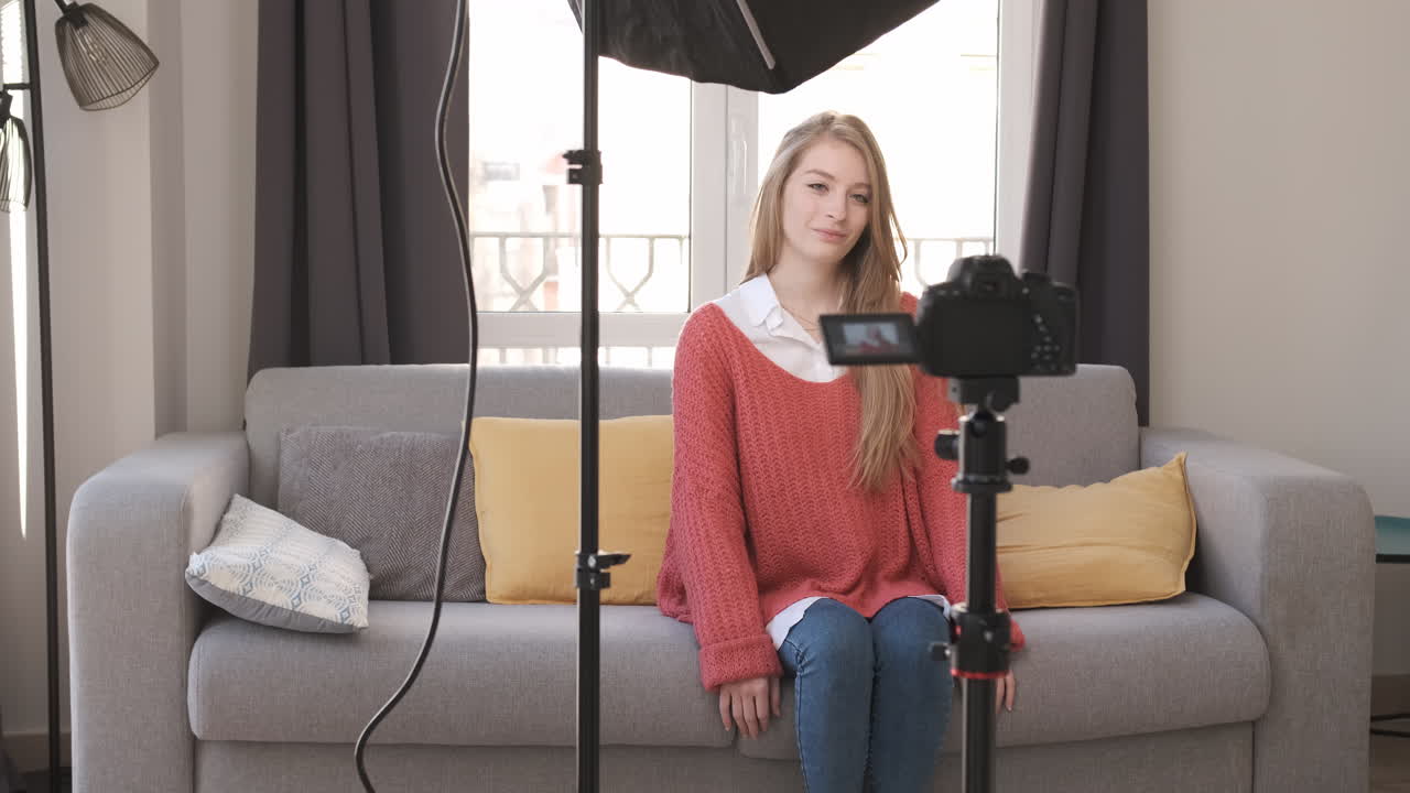 Vlogger recording youtube video at living room with camera