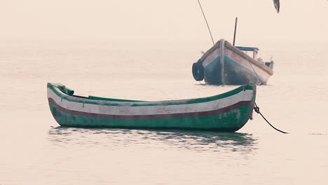 Kleines-Holzboot-Schaukelt-Und-Schaukelt-Auf-Ruhigen-Wellen-Im-Meer-Ohne-Menschen-Oder-Matrosen,-Ein-Kleines-Boot-In-Der-Nähe-Eines-Strandufers-Ohne-Menschen-In-Ruhigen-Wellen,-Hintergrundvideofilm-In-Full-HD