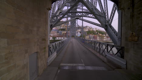 porto - portugal - march 18th 2020: empty famous landmark luis i bridge being crossed by bus during the coronavirus - covid19 pandemic and lockdown quarantine