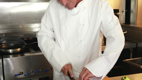 chef guapo cortando verduras y mostrando el pulgar hacia arriba