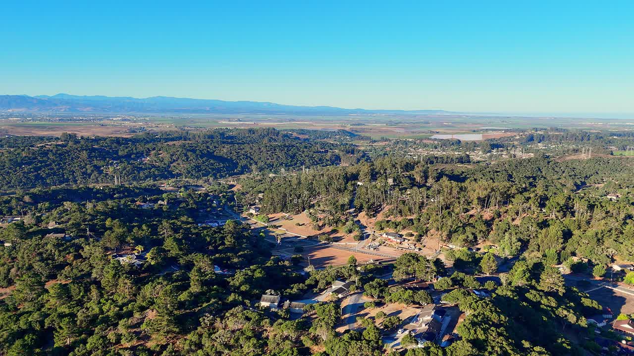 Elevated view of forest ridge near Salinas Valley under bright blue sky
