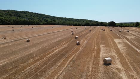 Drone-shot-rising-over-hay-bales-on-farm-field-in-Slovakia