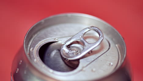 open aluminum can with water drops, zoom out shot