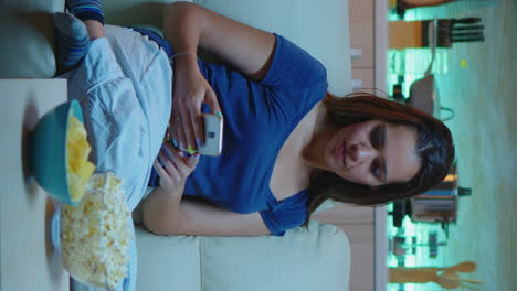 vertical video: lady using phone and watching tv
