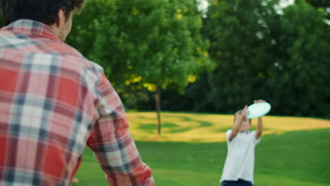 Family-playing-frisbee-in-field.-Parents-and-children-throwing-frisbee-disc