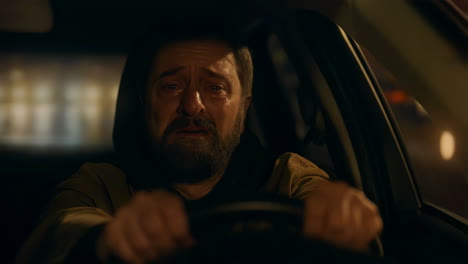 man crying while driving at night