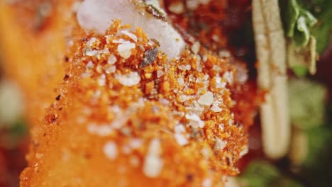 detailed macro shot of carrot with spices and herbs sprinkled on top