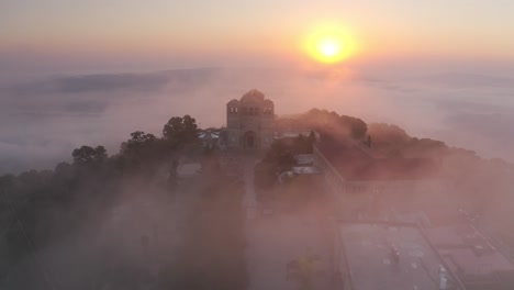 sunrise over a misty mountaintop church