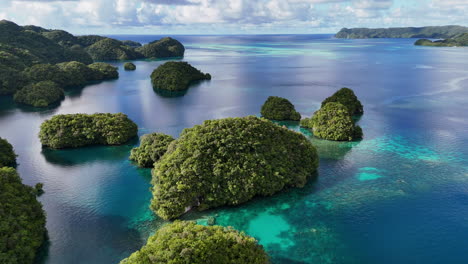 epic cinematic aerial drone shot encircling and showcasing the tropical waters and emerald island dots of palau
