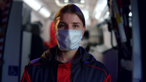 professional paramedic in medical mask posing at camera